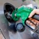 Closeup of hand holding a green gas pump filling up car